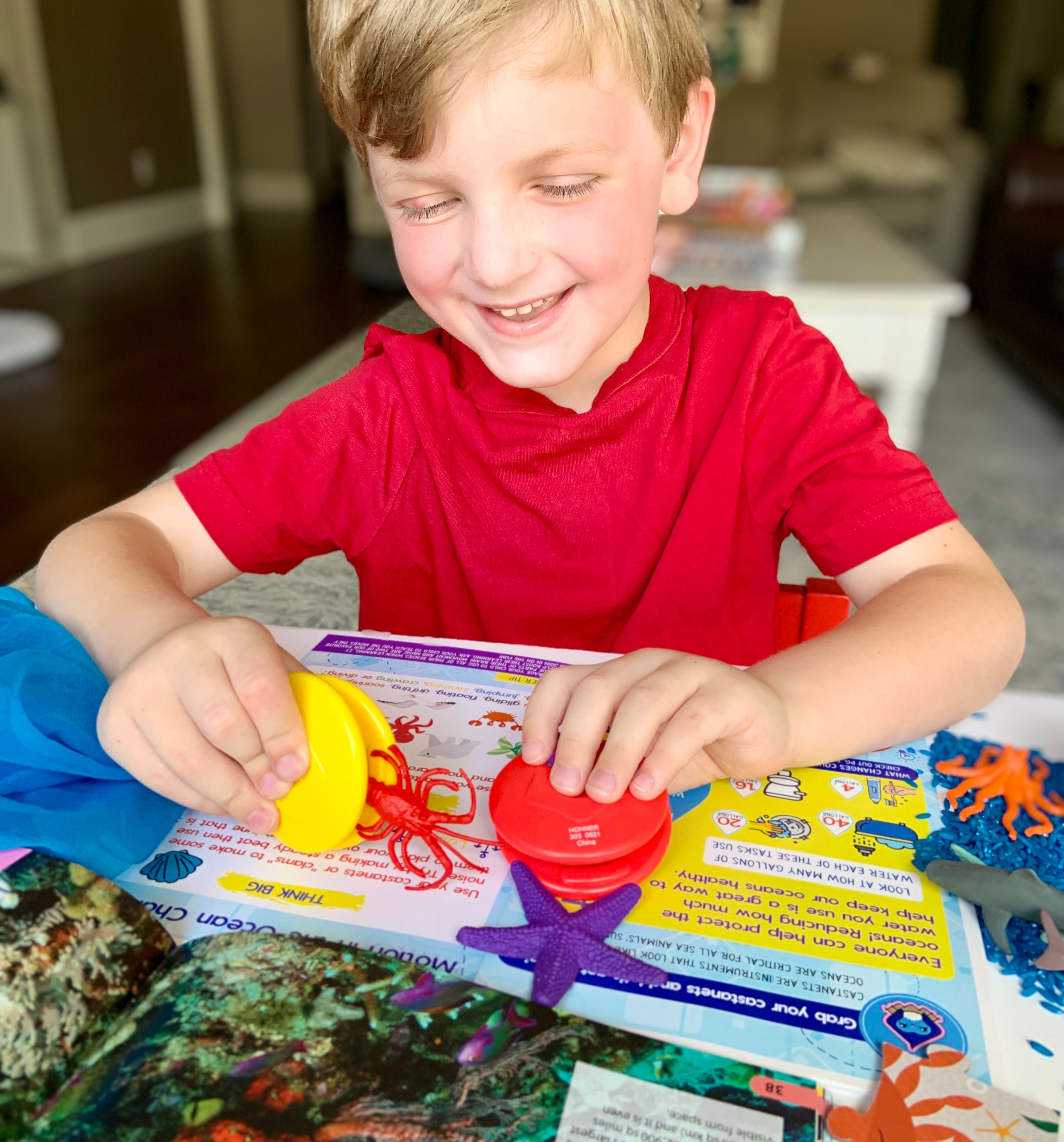 Smiling six year old boy playing with the Ocean Big Thinker Box