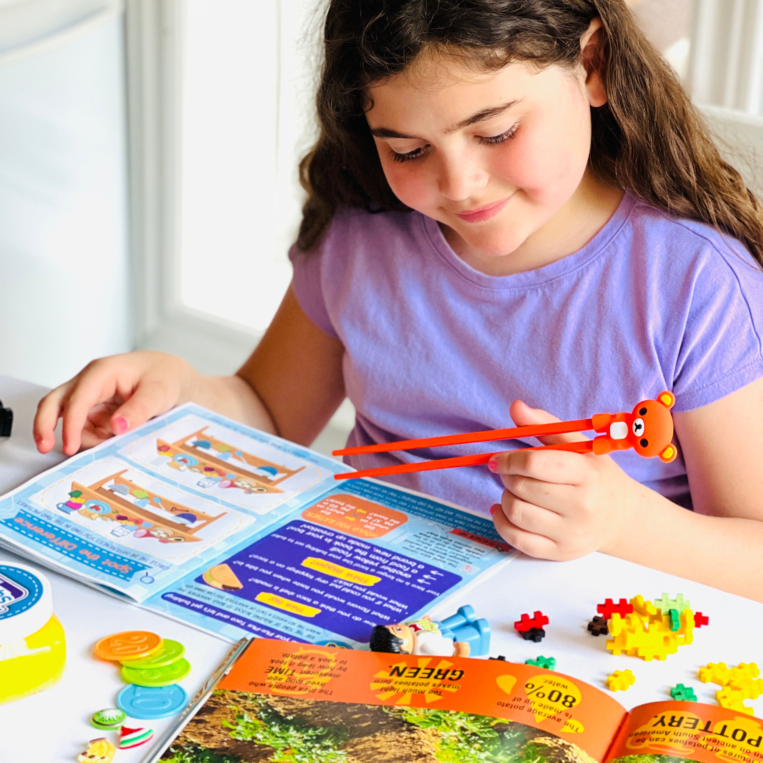 Smiling girl playing with World Kitchen Big Thinker Box educational toys.